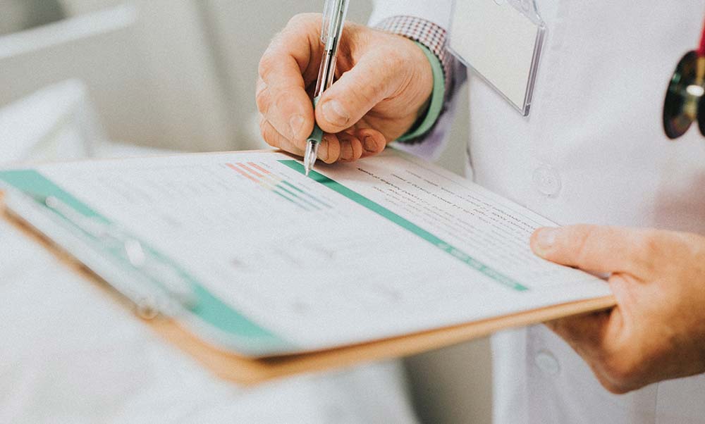 Person writing on clipboard